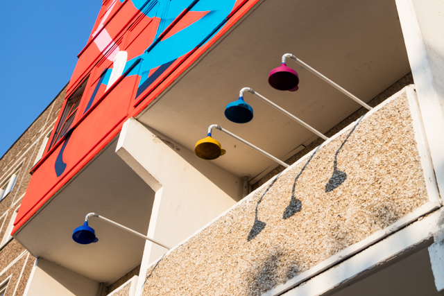 Balkon eines Plattenbaus mit Kunstinstallation